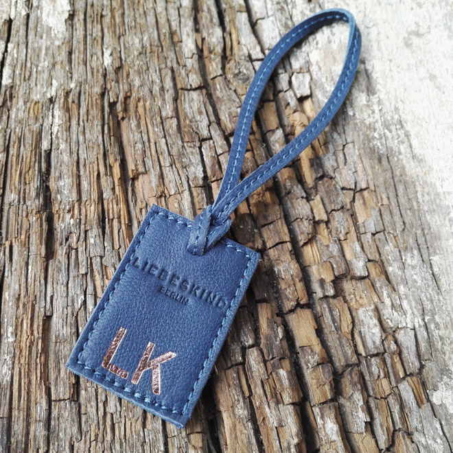 blauer Tag aus Leder mit Initialen in Kupfer geprägt