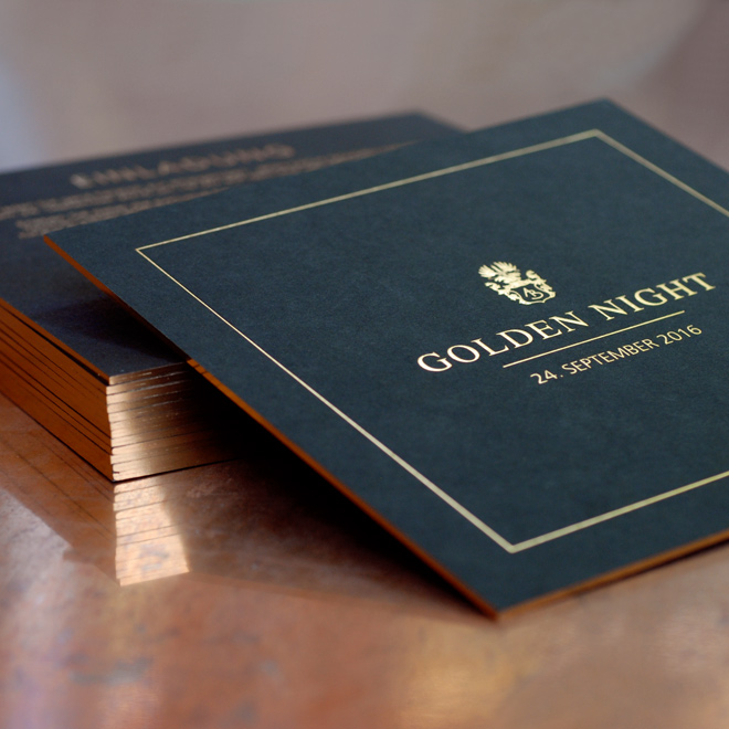 Schwarze Einladung mit Golddruck, goldener Prägung und goldenen Kanten.